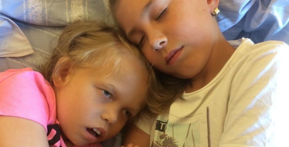 Rasmus och Mathilda håller om varandra i en säng.