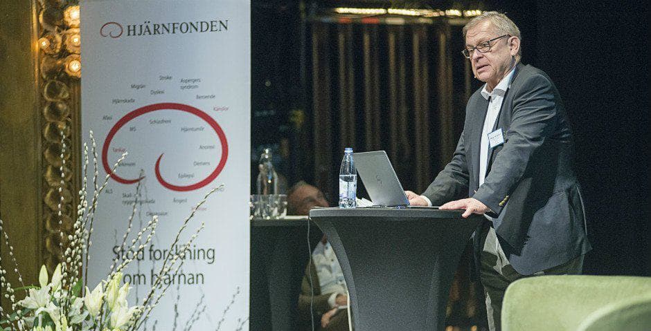 Bengt Winblad står vid ett bord och talar i en mikrofon.