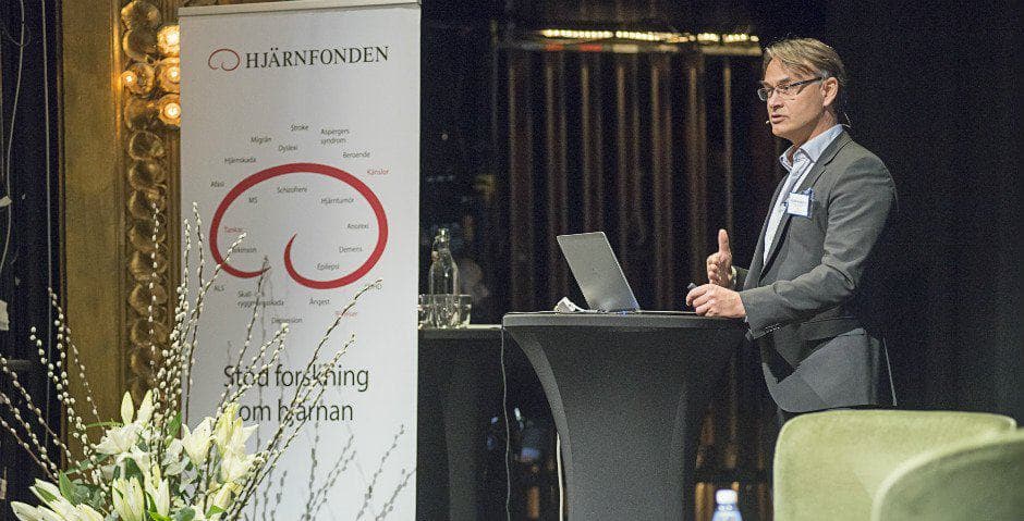 Niklas Marklund talar på scen i en mikrofon.
