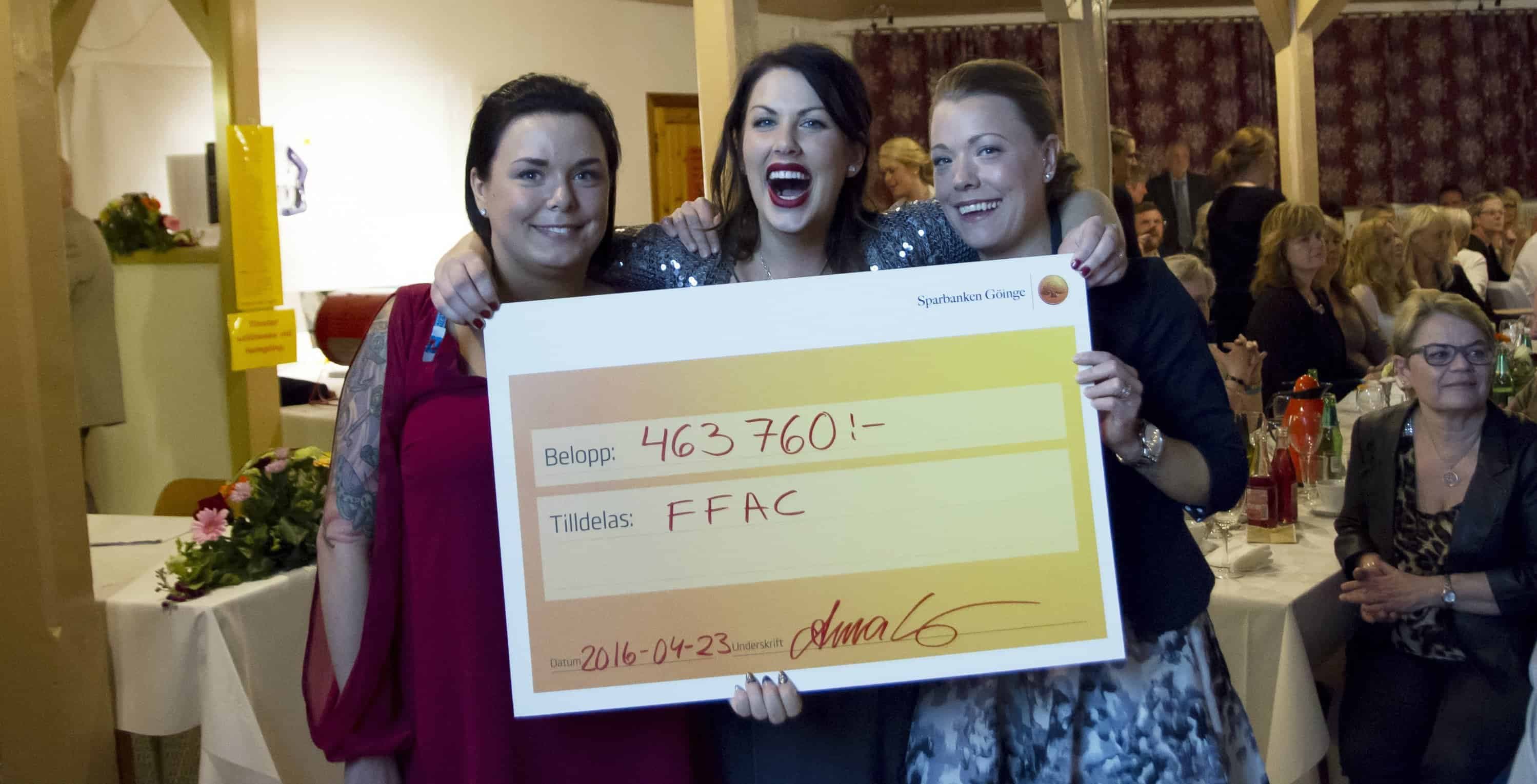 Frida Ekberg, Frida Karlsson och Ida Rasmussen står med en check.