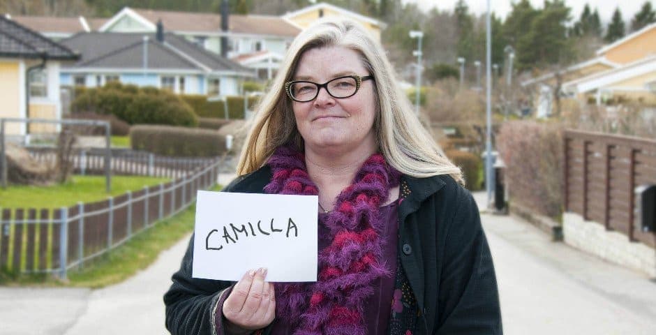 Porträtt av Camilla Langell som håller i en lapp där hon skrivit sitt namn på.