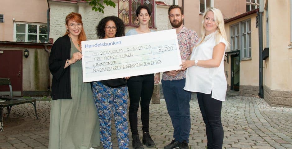 Lena Furberg, Annika Dahlqvist, Angelica Ogland och Olof Ogland står med Hjärnfondens Emelie Bäckelin och en stor check på 35 tusen kronor.
