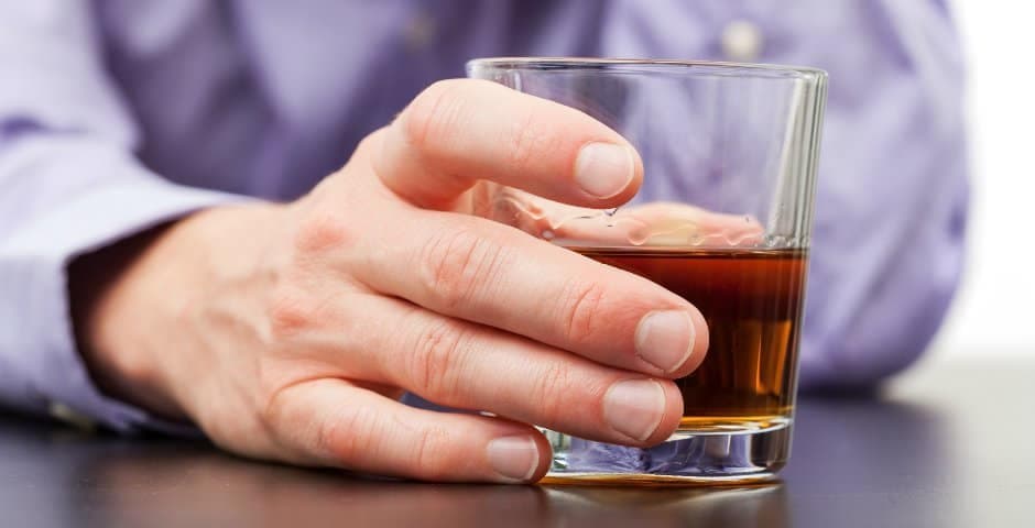 När bild på en hand som håller i ett glas med Whiskey.