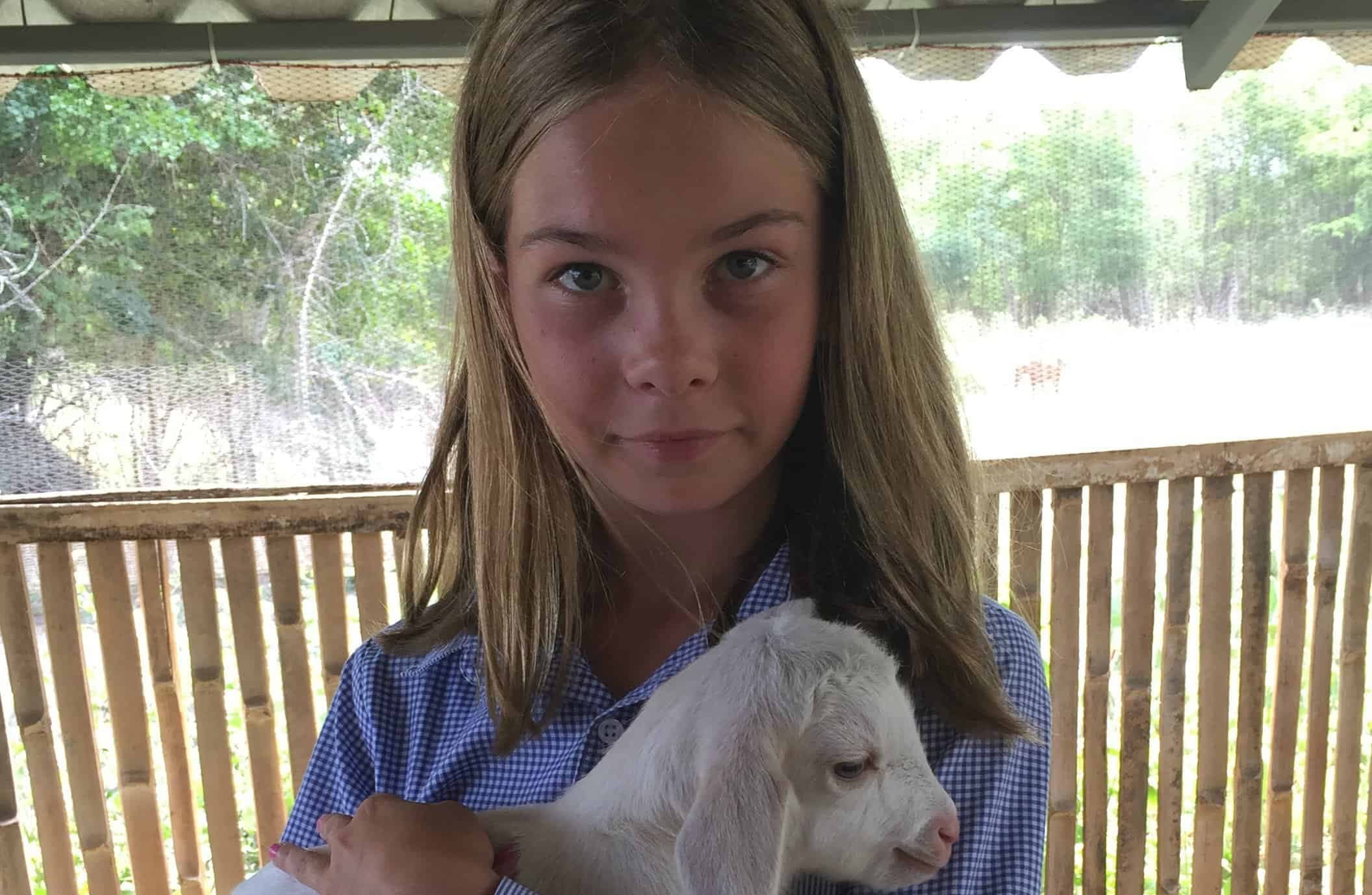 Porträtt av Grace Brungardt som håller ett litet lamm i sin famn.