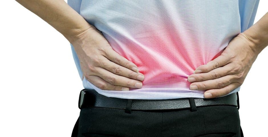 En person håller händerna mot ländryggen som lyser upp rött.