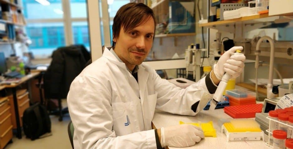 Porträtt av Olof Gissberg när han arbetar i ett labb.