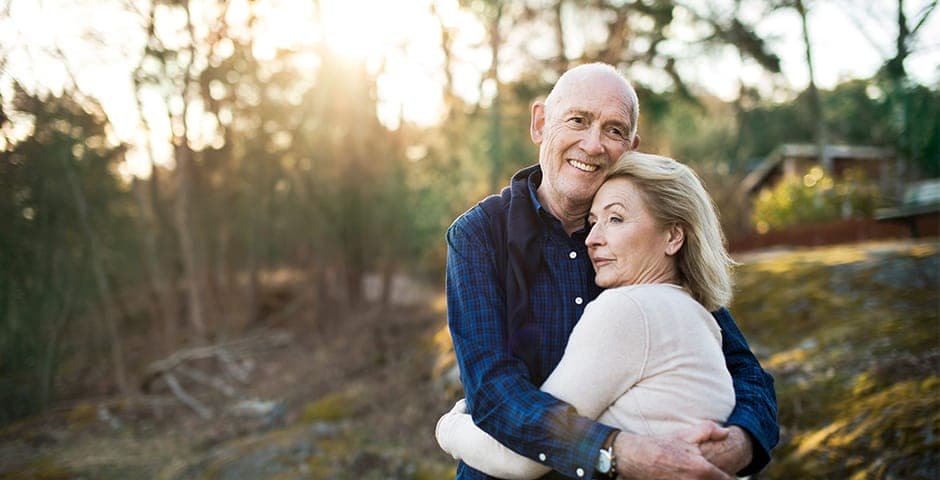 Man håller om en kvinna i solljus.