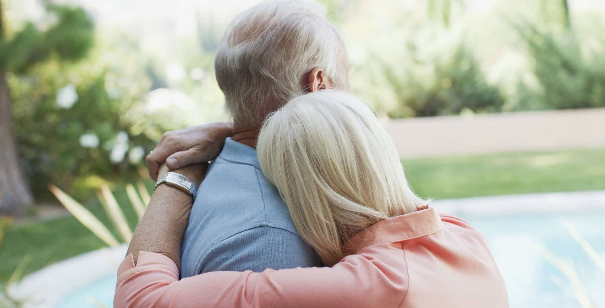 Ett äldre par kramar om varandra.