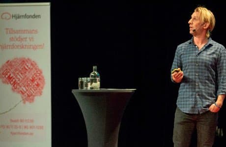 Anders Hansen står på en scen och talar.