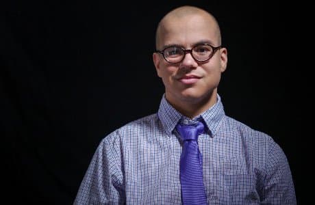 Porträtt av en ung man med glasögon och slips.