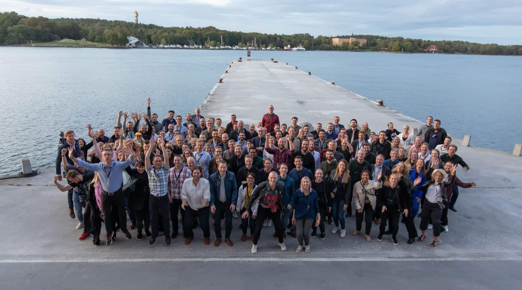 Alla anställda på cygni står tillsammans på en kaj i en gruppbild.