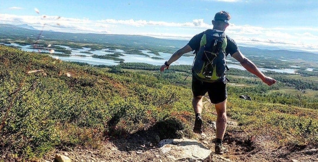 Kristian Luoma på ett berg med utsikt över flera små öar.