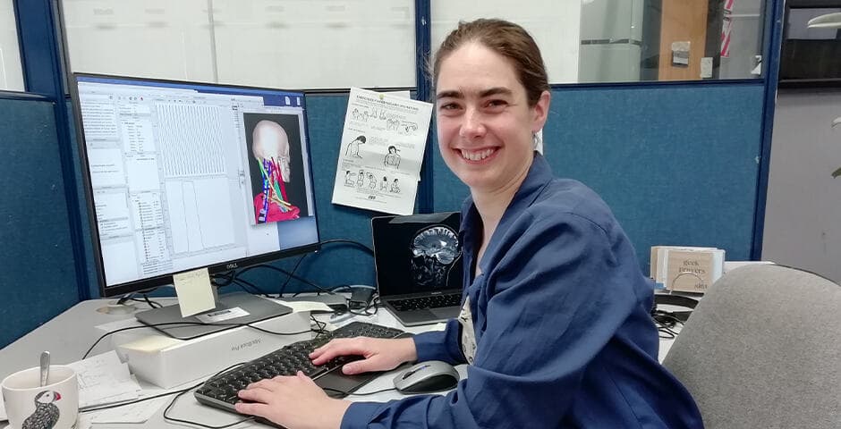 Karin Lundegård sitter vid sitt skrivbord och dator.