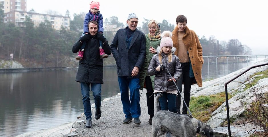Flera generationer i en familj promenerar tillsammans.