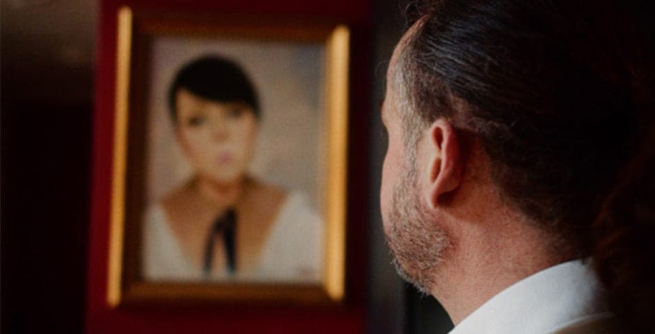 Henrik tittar på en tavla som föreställer hans dotter Caroline.