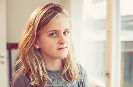 Ung flicka som tittar mot kameran.