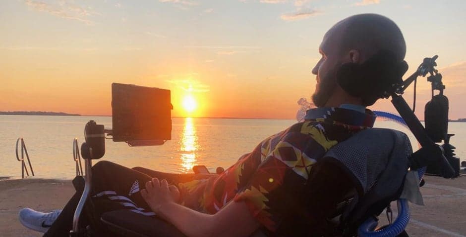 Charlie Hägg sitter i permobilen vid havet.