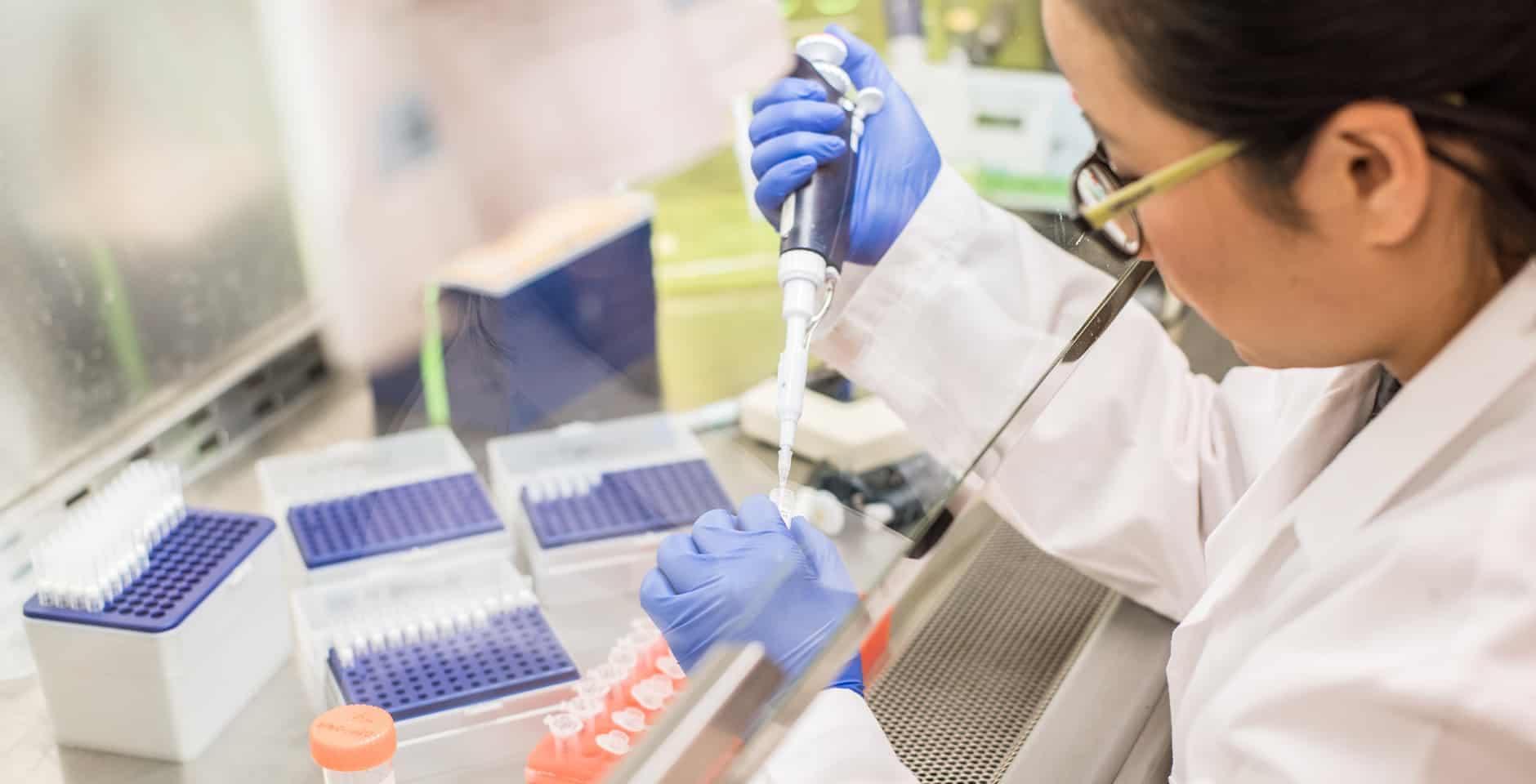 Kvinnlig forskare arbetar i dragskåp.