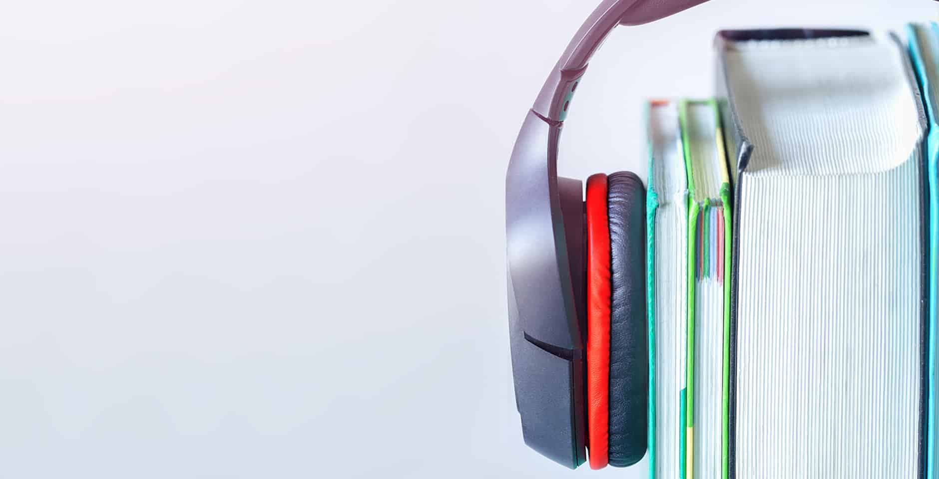 Hörlurar som sitter runt böcker.