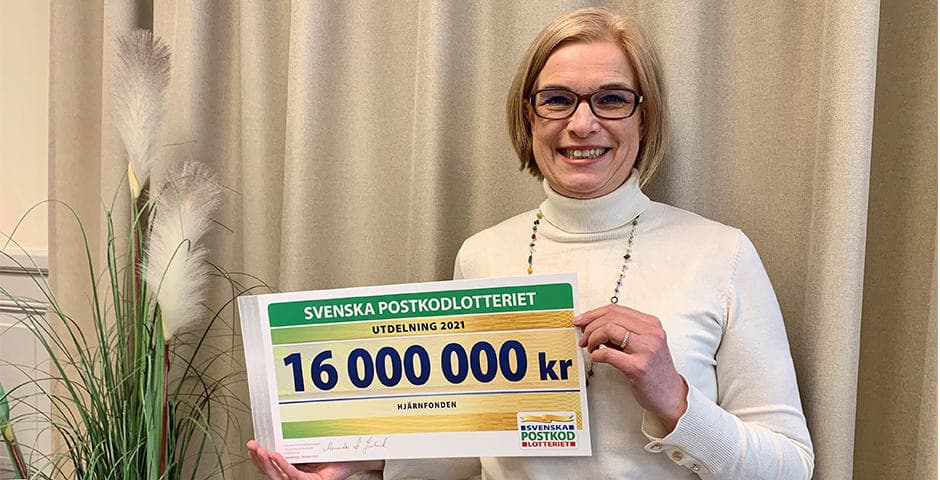 Anna Hemlin står med en check på 16 miljoner kr från Svenska Postkodlotteriet.