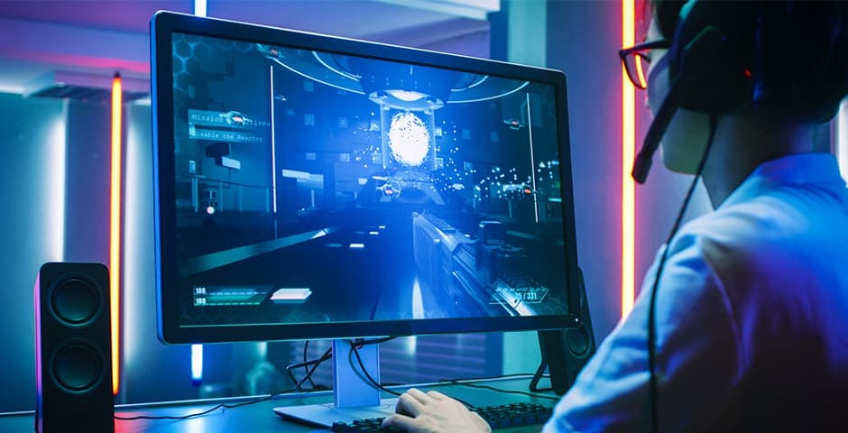 En kille sitter och spelare på en dator.