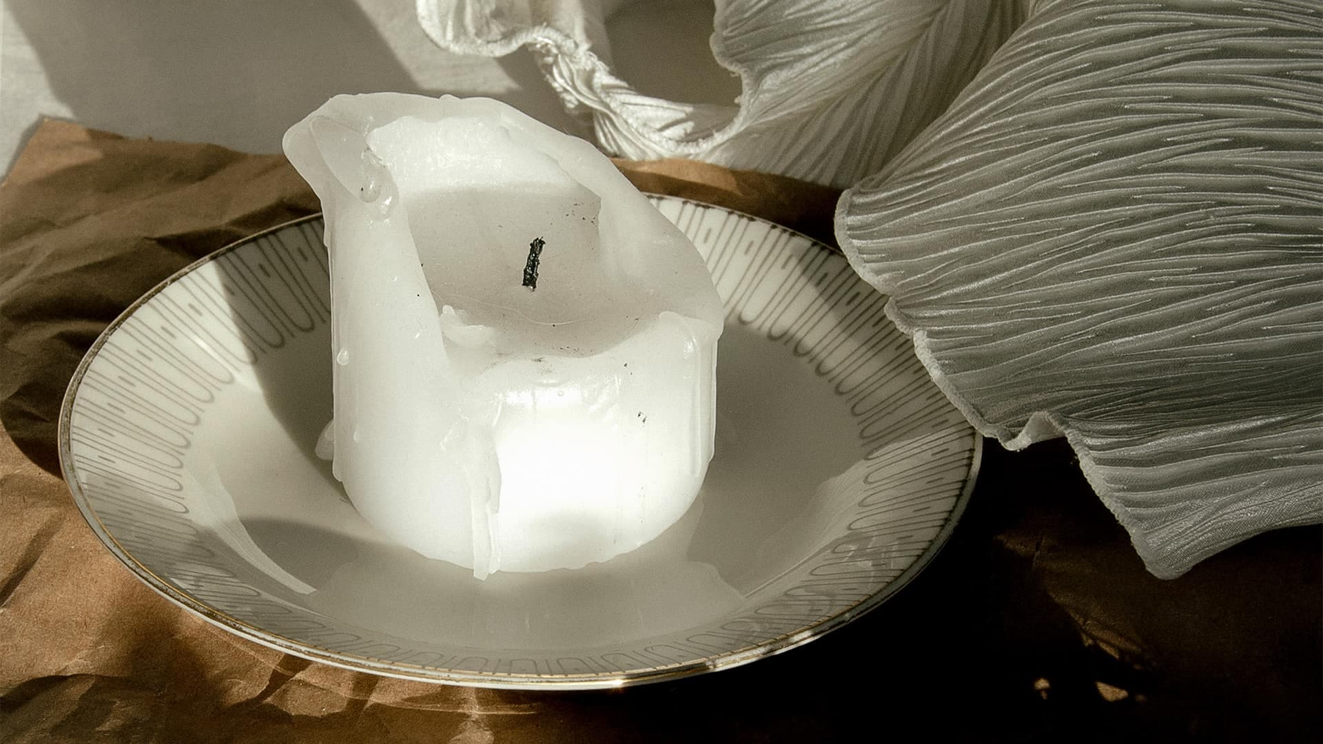 Ett vitt blockljus på ett träbord.