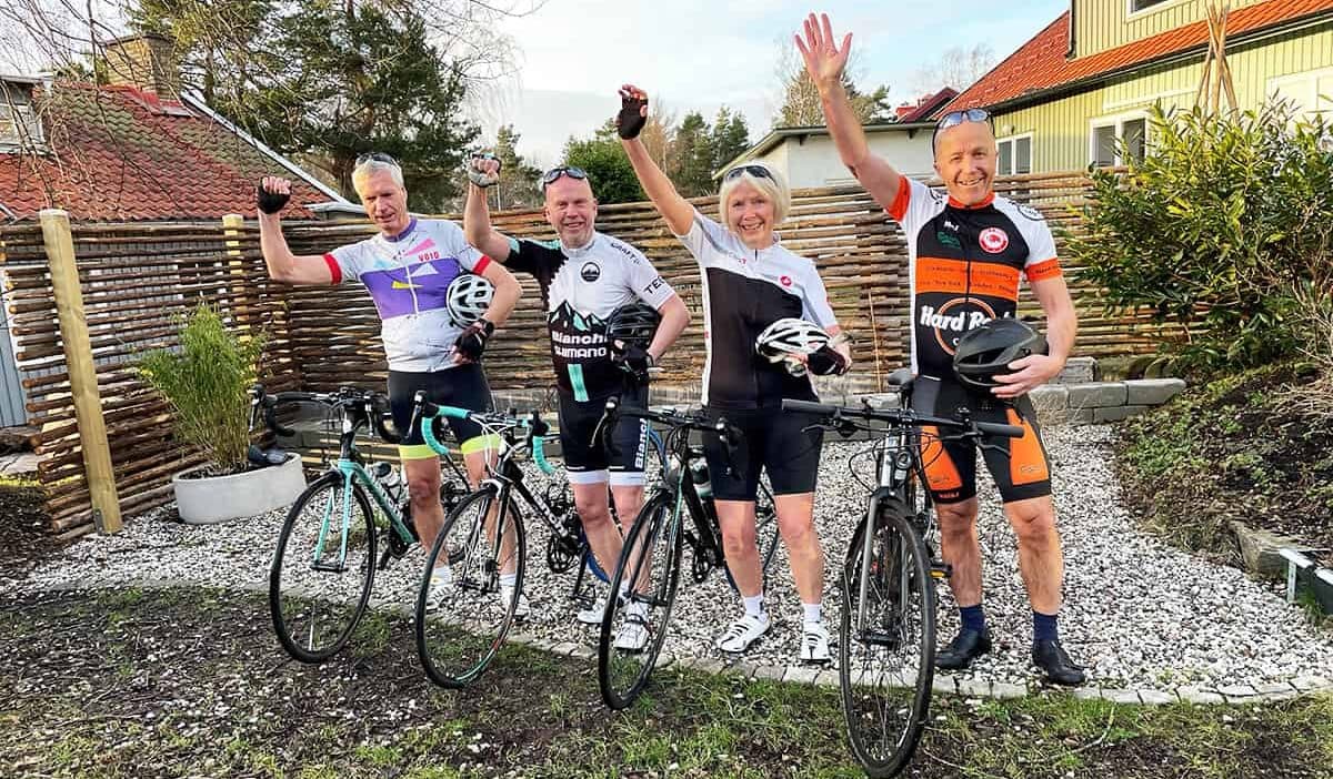 Thomas, Peter, Anette och Per poserar med sina cyklar, iklädda träningskläder.