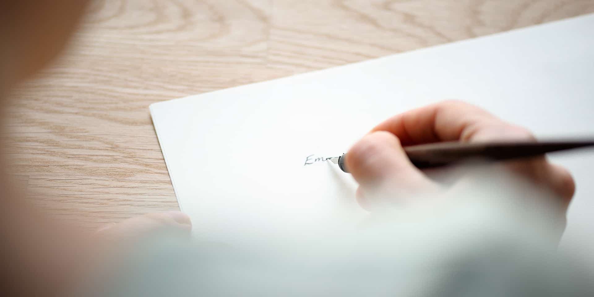 En närbild på någon som skriver på ett kort.