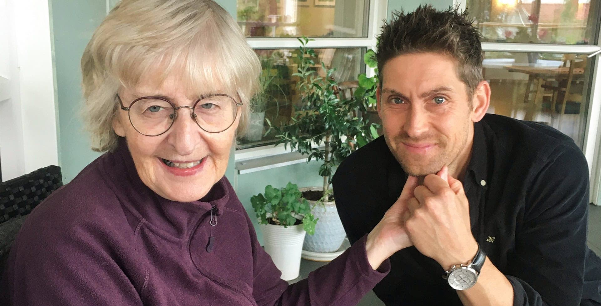 Ett porträtt på Joakim och hans mamma Rigmor som håller hand.