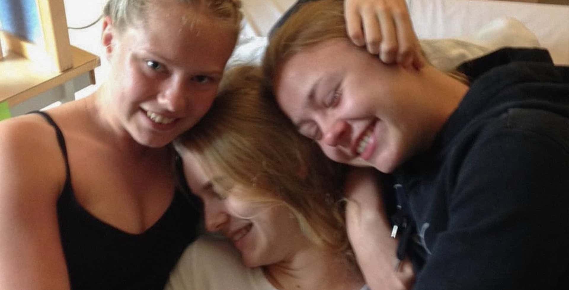Emma Vesterlund kramas om av sina vänner i en sjukhussäng.