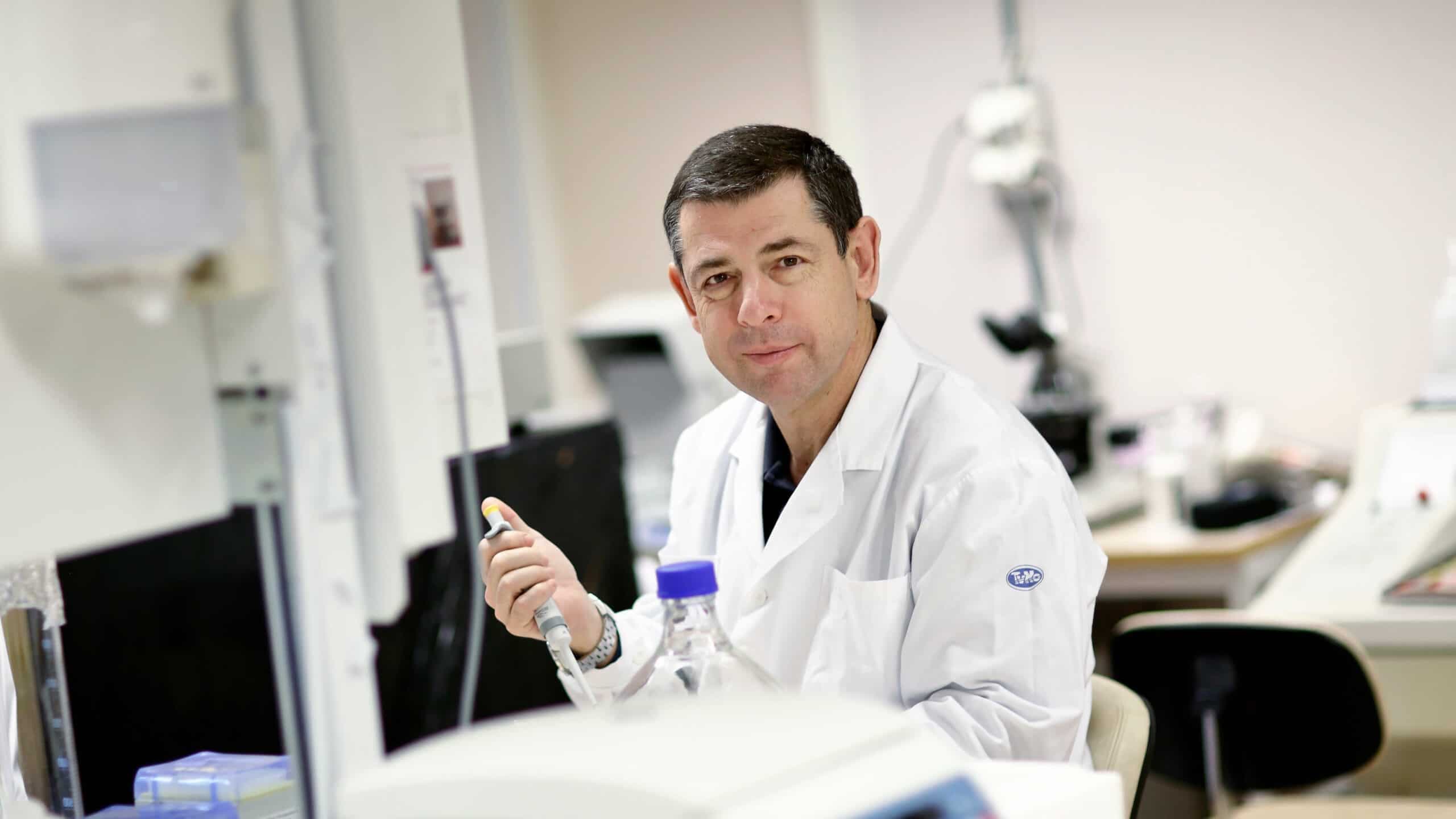 Porträtt av Markus Heilig sittande i vit rock i en laboratoriemiljö.