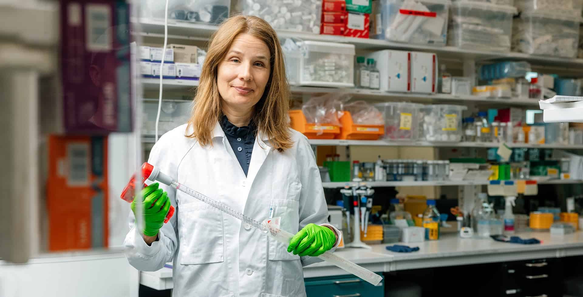 Porträtt av Andrea Carmine Belin, docent och forskargruppledare som står i en vit labbrock.