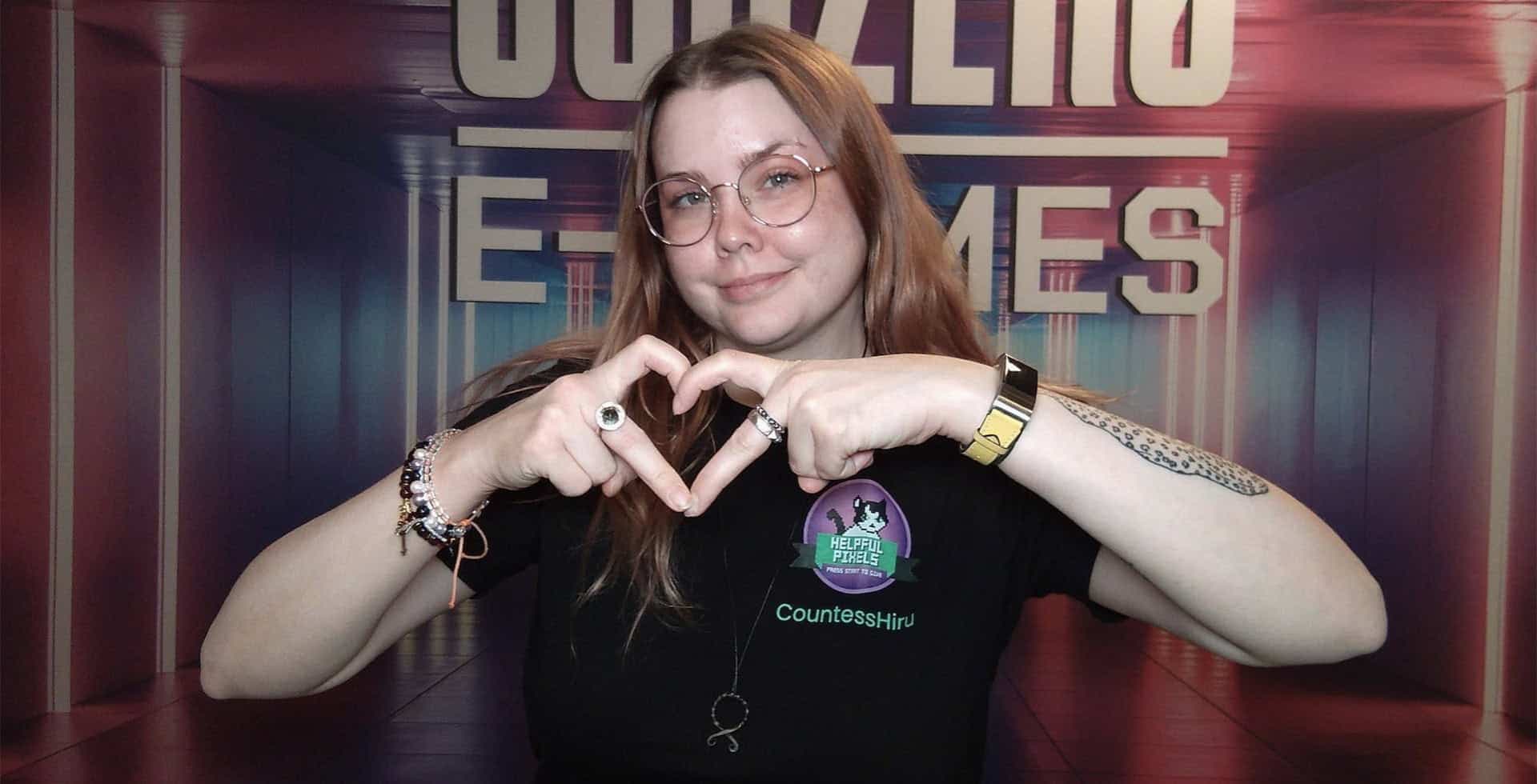 Porträtt av Maria Backman som gör ett hjärta med hennes fingrar.