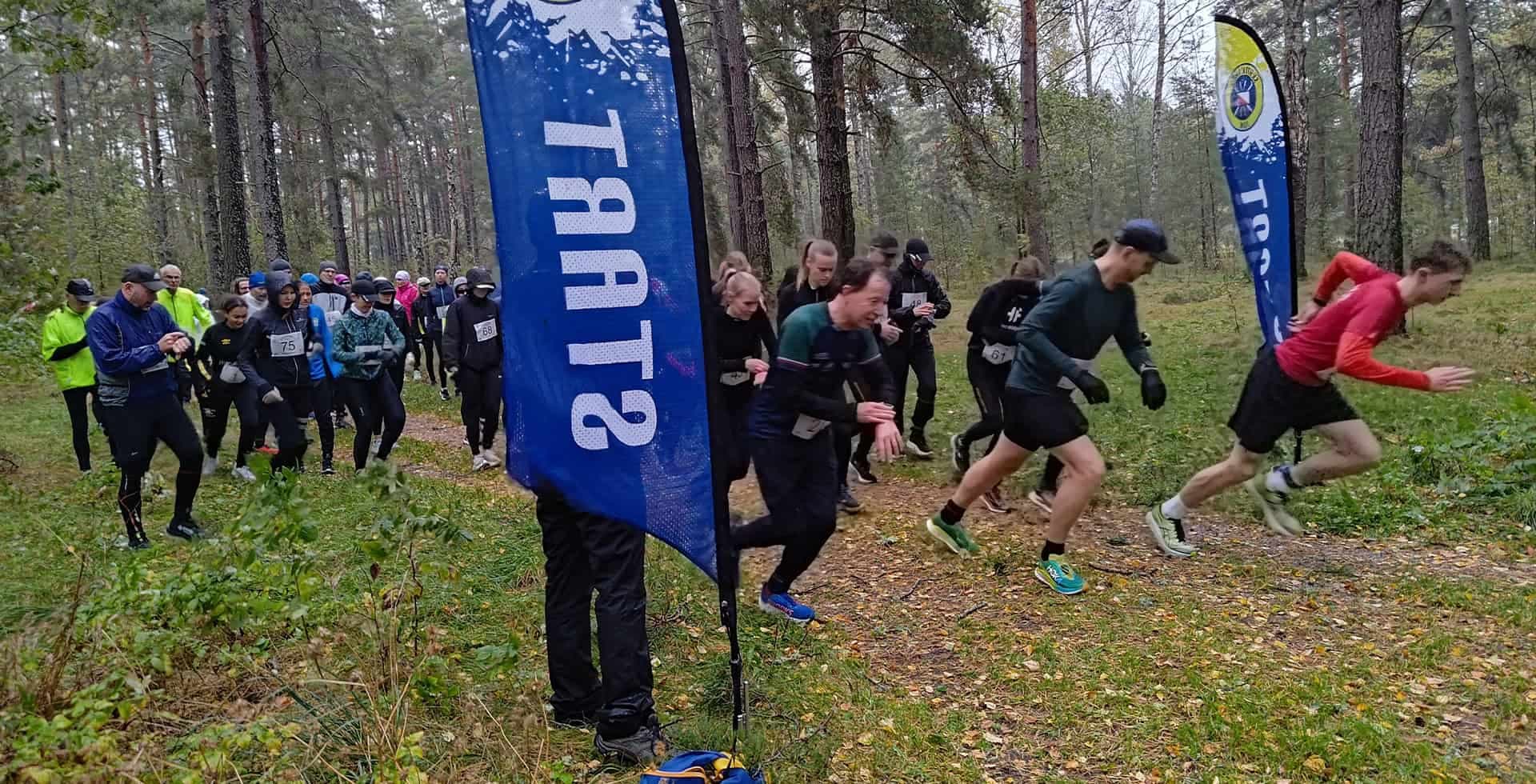Flera personer passerar startlinjen i ett lopp.